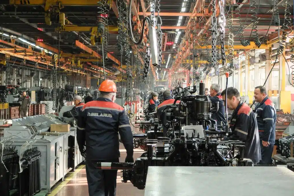 Workers assembling machinery in a Belarusian factory in 2025, illustrating the challenges and resilience of the Belarus economy under sanctions.