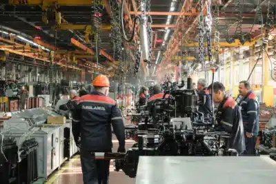 Workers assembling machinery in a Belarusian factory in 2025, illustrating the challenges and resilience of the Belarus economy under sanctions.