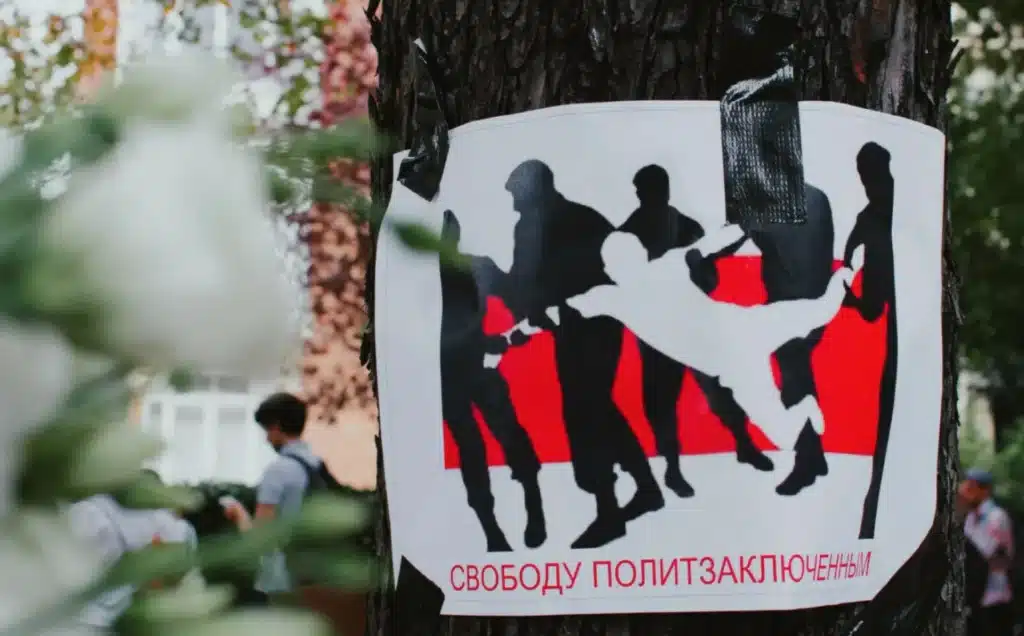 Poster calling for the release of political prisoners in Belarus, taped to a tree during a protest in 2025, symbolizing resistance and human rights activism.