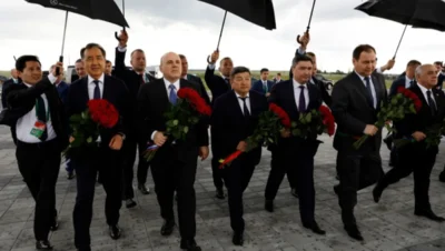 Belarus economic crisis illustrated by officials in suits holding red roses under umbrellas during a formal ceremony, symbolising political control amid sanctions and mismanagement.