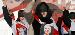 Women protesting in Belarus with eyes covered, holding a portrait of political prisoner Maria Kolesnikova, wrapped in the historical white-red-white flag — a powerful example of Belarus resistance art against state repression.